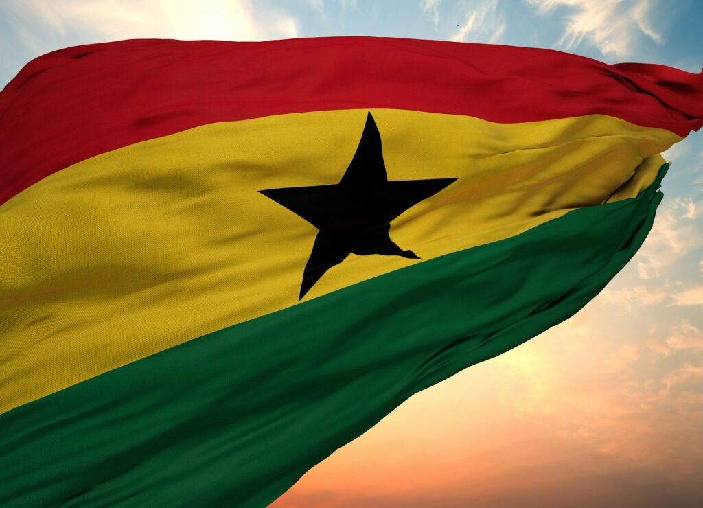 Closeup view of the waving flag of the Ghana on a background of sunset